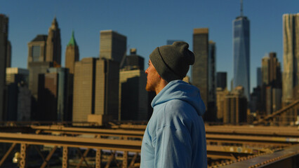 A man standing with Manhattan skyline views in New York City, USA