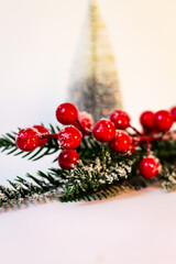 Festive New Year decoration and card, decor made of Christmas tree branches and red berries on a background of a cone-shaped Christmas tree with sparkles.