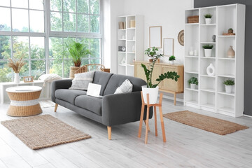 Interior of living room with modern sofa, coffee table and shelving units