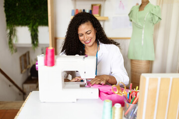 A mature woman focused on her sewing project in a colorful office. Surrounded by threads and tools, she showcases her design skills with a sewing machine and vibrant fabric.