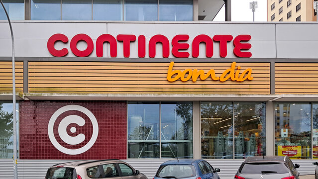 Continente bom dia supermarket facade with logo and cars parked in front