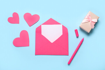 Envelope with blank card, pen, gift box and paper hearts on color background. Valentine's Day celebration
