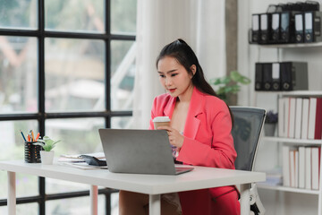 Fototapeta premium Focused Professional Woman Working on Laptop in Modern Office 