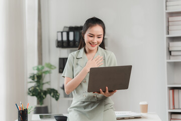 A Moment of Joy:  A professional woman beams with delight as she reads good news on her laptop, radiating positivity and success.  She's surrounded by the familiar comforts of her office.