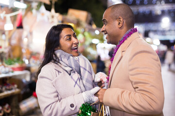 Portrait of happy couple in love at christmas street fair