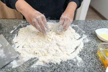 A person is making bread dough on a counter