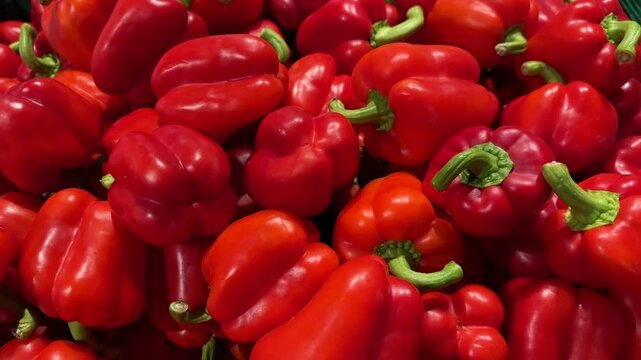 Vibrant red bell peppers filling the frame in a grocery store produce section