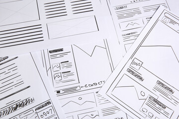 Developing UI design. Sketches of website wireframes as background, above view