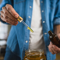 close up of man herbalist prepare natural oils in a rustic workshop