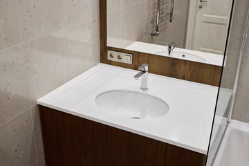 A Stylish and Modern Bathroom Vanity Featuring a Mirror and Faucet for Enhanced Aesthetics