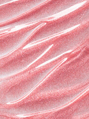 Shimmering pink lip gloss texture background. Smudged cosmetic product smear. Makeup lipgloss swatch product sample