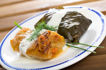 Cabbage and grape rolls in leaves at plate, dish of Eastern European cuisine