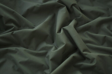 Texture of Dark green military uniform textile cloth with folds