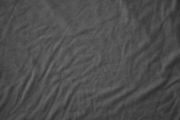 Texture of Dark grey crumpled textile cloth part with small folds