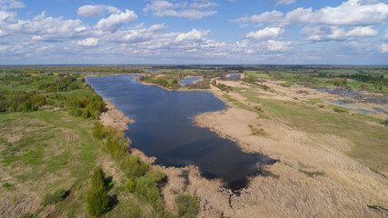 Large body of water is surrounded by a field of tall grass