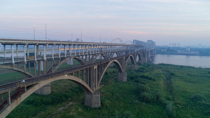 Bridge spans a river with a city in the background