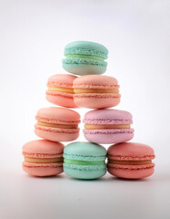 Obraz premium Pastel colored macarons arranged like a pyramid on a white background