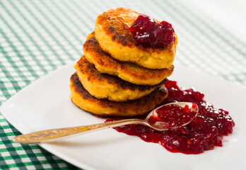 Image of stack of fried quark pancakes with jam served at plate