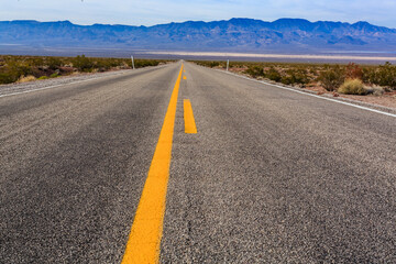 A long, empty road with a yellow line down the middle