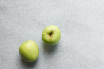 Overhead view of a whole green apple on a white granite countertop, top view of a crisp green apple on a white countertop