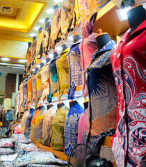 Colorful batik shirts displayed on mannequins in a shop. Selective focus on the shirts, wide-angle shot captures the vibrant display. Perfect for fashion blogs or promoting Indonesian culture