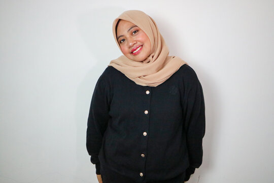 happy young asian muslim woman standing on isolated white background. A beautiful muslimah wearing abaya and hijab costume shot in studio
