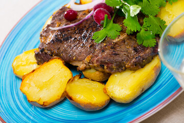 Appetizing beef steak with slices of baked potato and parsley
