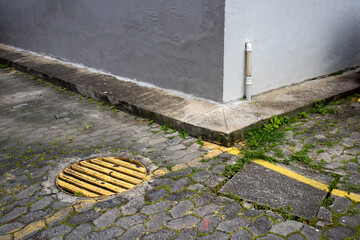 corner of low-cost urban condominium building showing wall, sidewalk on floor made of hexagonal...