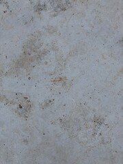 Close-up of a weathered white surface featuring fine cracks, subtle stains, and imperfections, ideal for vintage or distressed textures.