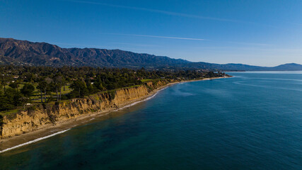 DECEMBER 2022, SANTA BARBARA, CA - USA - aerial view of famous Santa Barbara beach bluffs and with mountains and palm trees in background - near Montecito