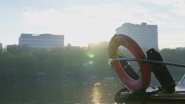 Sunset reflections over a canal with a boat and lifesaver