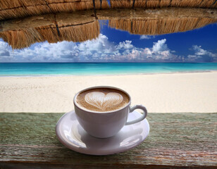 tasse de café dessin de cœur dans la mousse sur une plage de la mer des tropiques