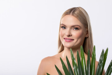 Naklejka premium A Stunningly Beautiful Woman Posing Gracefully with a Tropical Plant in a Bright Studio