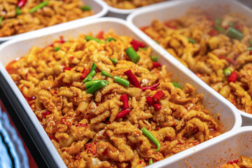 Vibrant Spicy Noodles with Colorful Garnishes in a Buffet Setting