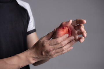 Man suffering from pain in hands and fingers, arthritis inflammation. Red highlight