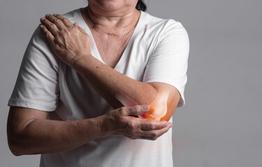 X-ray of elbow,Woman in her 70s holding her elbow with a red pain point. elbow paint and joint pain...