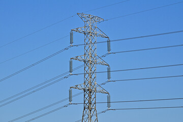 Voltage power lines or high voltage electric transmission tower with blue sky