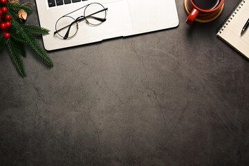 Fototapeta premium Beautifully arranged desk with gift wrapped in festive paper, laptop, coffee cup and pine branches