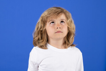 Child boy thinking on isolated background. Think and idea. Thoughtful kid studio portrait. Doubt and concerned kids expression. Looking up on copy space.