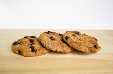 Row of chocolate chip cookies on a wooden board