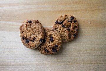 Row of chocolate chip cookies on a wooden board