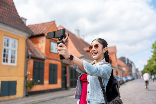 Asian woman traveler use camera record vlog while traveling in the city.