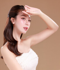 Obraz premium Elegant Asian woman model with natural makeup on face clean fresh skin on isolated Beige background.