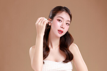 Elegant Asian woman model with natural makeup on face clean fresh skin on isolated Beige background.