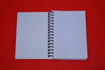 book with blank paper for text copy space, isolated on red background. top view