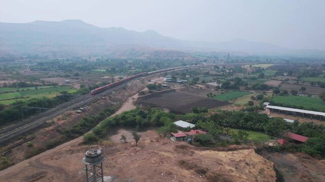 Aerial view of the saffron coloured Vande Bharat Express near Pune India. This train is between Pune and Kolhapur and also a tri-weekly train between Pune and Hubbali.