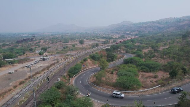 Aerial view of the saffron coloured Vande Bharat Express near Pune India. This train is between Pune and Kolhapur and also a tri-weekly train between Pune and Hubbali.