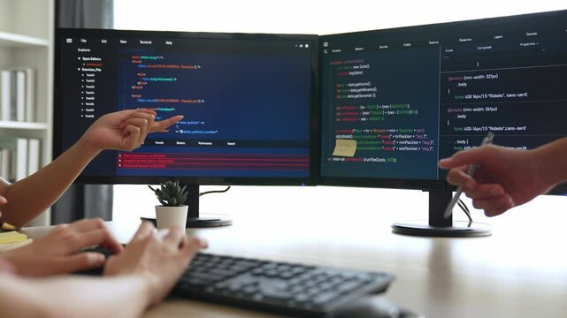 Slow motion back end software developer engineer for computer programming working together on debugging writing computing code, solving complex algorithms display on monitor in office. Burgeoning