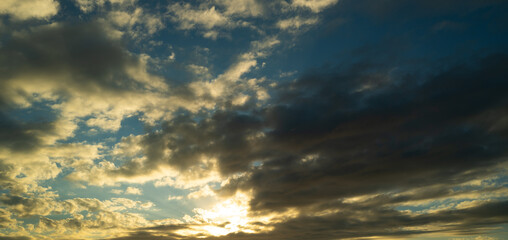 Sunset or sunrise. Dramatic majestic scenery sunset. Sky with clouds in sunset sky light background. Sunrise with clouds in various shapes. Calm sunset sky and sun through clouds over.