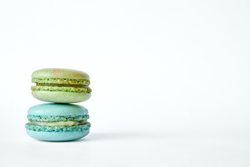 Stack of two colorful French Macarons, cakes with different flavors, mint and apple flavor. pyramid of homemade dessert, macaroons aquamarine, green color. Side view, Copy space for text